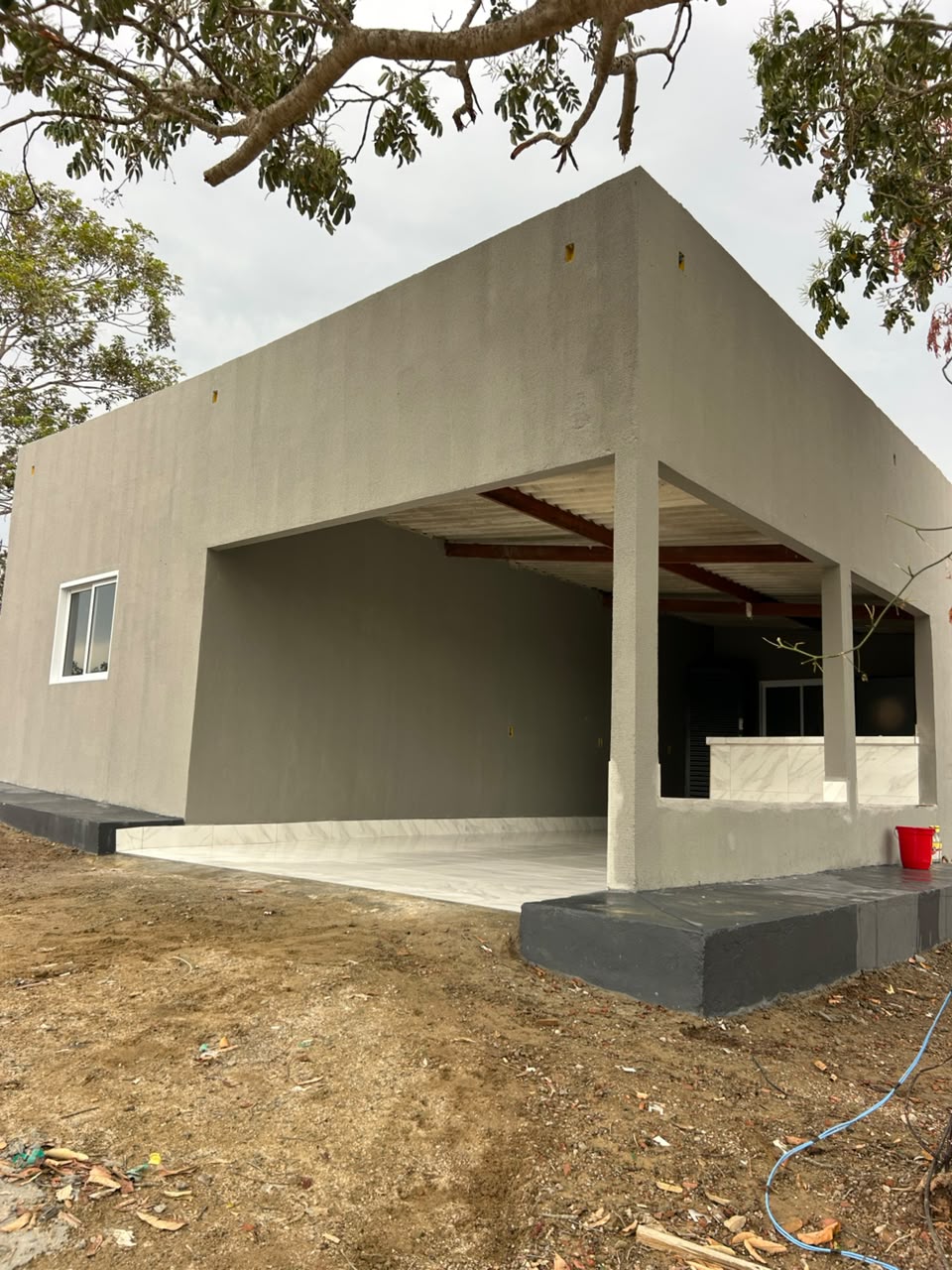 Varanda coberta da chácara, com piso claro e abertura para a área externa
