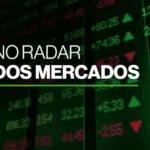 Telas de negociação em alta com barras de ouro em primeiro plano, simbolizando crescimento de ações de tecnologia e recorde de metais preciosos