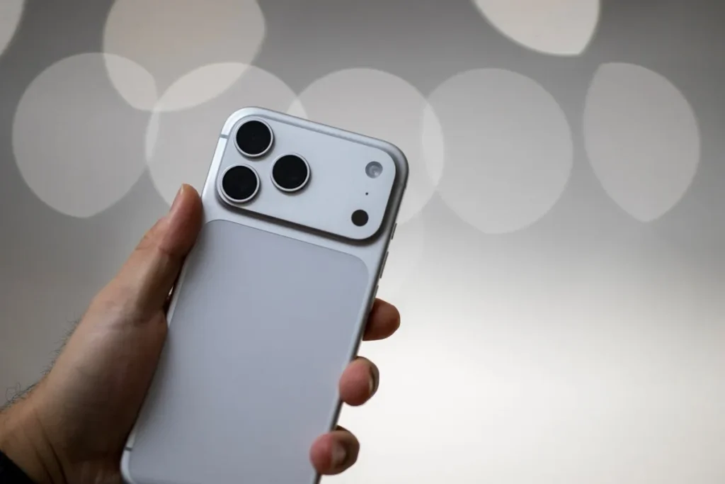 Apple fecha parceria com Google para levar o Gemini aos iPhones por meio da Siri 1 iPhone com Siri no ecrã, com prédios da Apple e do Google desfocados ao fundo