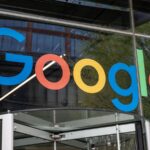 Smartphone com logos do Google e Android sobre documentos legais