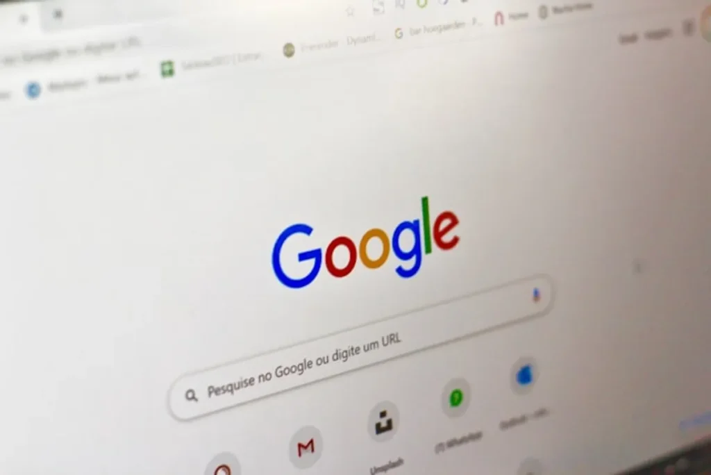 Reino Unido quer limitar uso de conteúdo por IA do Google 1 Fachada da CMA em frente a tela com logo do Google, imagem editorial