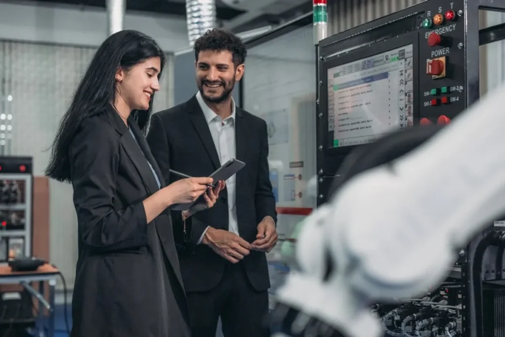 USP lança novo curso de inteligência artificial, otimização e internet das coisas para indústrias e negócios 1 Profissional trabalhando em laptop com gráficos e sensores IoT em ambiente industrial ao fundo